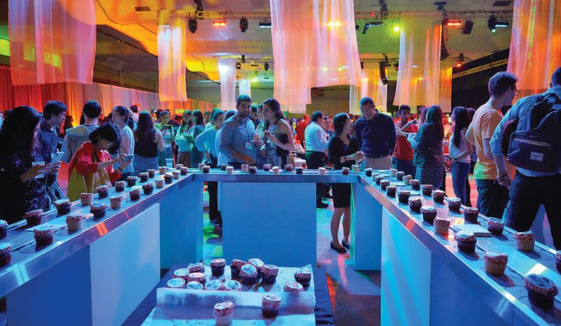 Bei Toast to Tech machen die Feiernden eine Pause vom Tanzen zur Live-Band im Johnson Athletic Center und holen sich eine Leckerei vom Cupcake-Förderband.