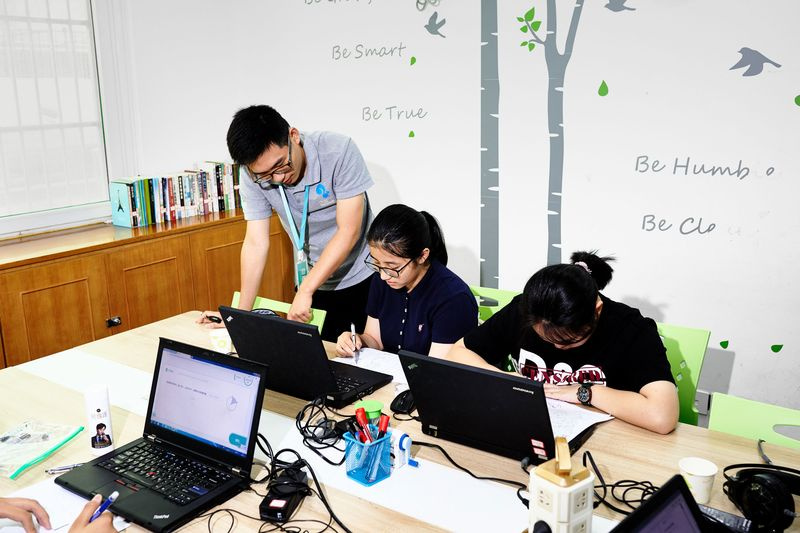 Une salle de classe, montrant des étudiants sur des ordinateurs portables et un enseignant aidant, à Squirrel AI