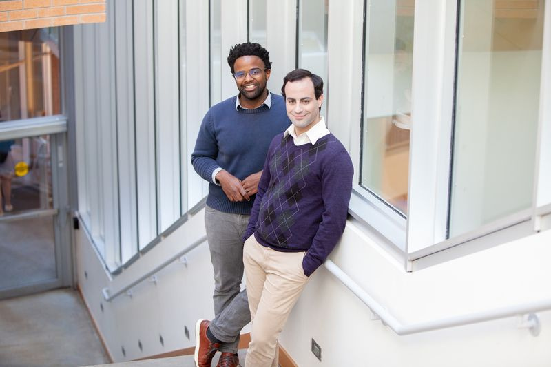 Michael Carbin und Jonathan Frankle, die Autoren der Zeitung, posieren auf einer Treppe.