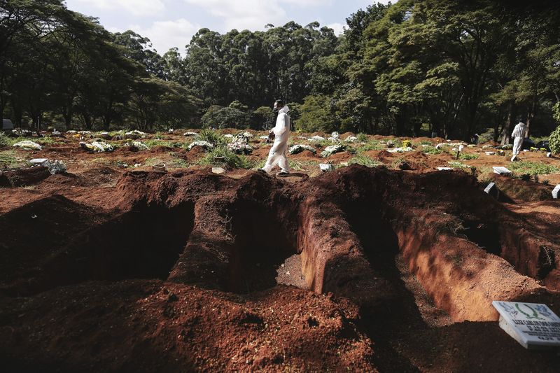 SP - Sao Paulo - 28.04.2021 - COVID-19 SAO PAULO, FRIEDHOF VILA FORMOSA - Coveiro mit persönlicher Schutzausrüstung wird vor offenen Gräbern auf dem Friedhof von Vila Formosa, Ostseite der Stadt Sao Paulo, gesehen diesen Mittwoch (28.) Die Zahl der Todesfälle im Zusammenhang mit der COVID-19-Pandemie (Coronavirus) liegt in Brasilien bei fast 400.000, wobei der Bundesstaat Sao Paulo am stärksten von der Krankheit betroffen ist. Foto: Ettore Chiereguini / AGIF (via AP)