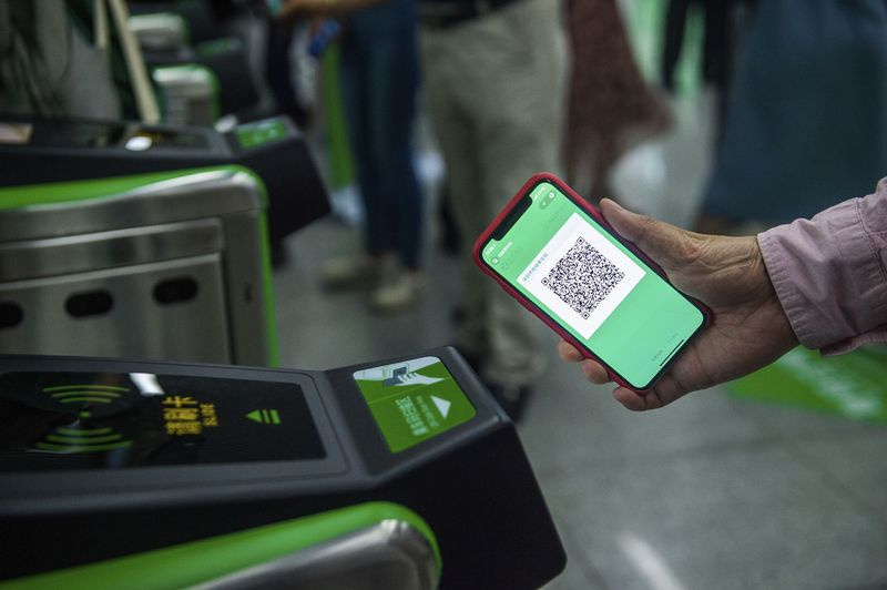 Un usager du transport en commun utilise son téléphone pour payer un trajet en utilisant WeChat Pay.