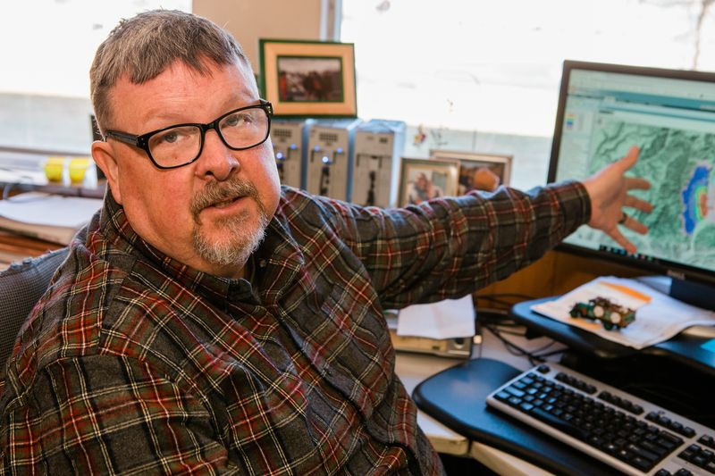 Foto von Chuck, während er in seinem Büro im Missoula Fire Lab arbeitet und ein Programm verwendet, das die Brandaktivität und die Ausbreitungswahrscheinlichkeit modelliert. Das Programm ermöglicht es Wissenschaftlern, die Brandausbreitung zu modellieren und anschließend zu bestimmen, ob Maßnahmen ergriffen werden müssen oder über welche Maßnahmen sie nachdenken sollten. Oder umgekehrt gar keine Aktion.
