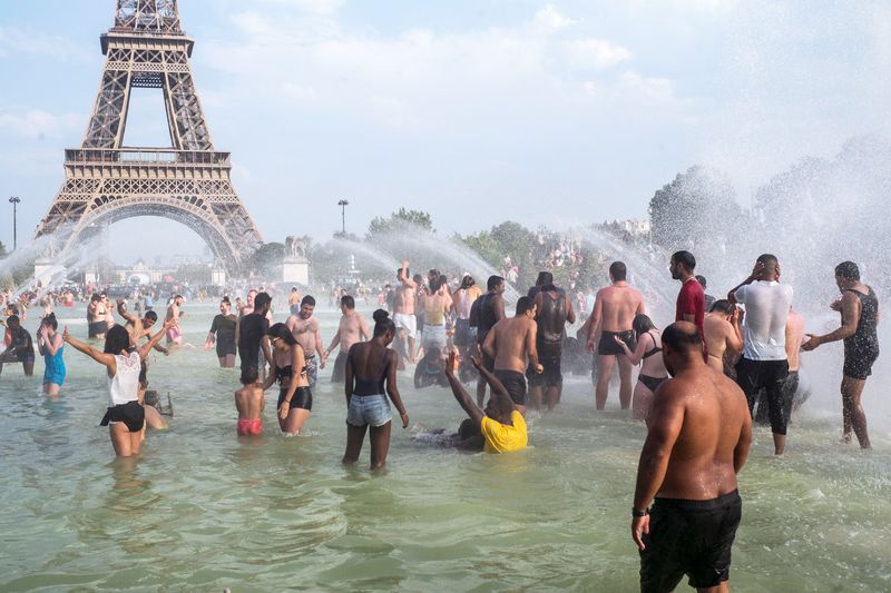 Les gens se rafraîchissent dans les fontaines des jardins du Trocadéro à Paris, jeudi 25 juillet 2019