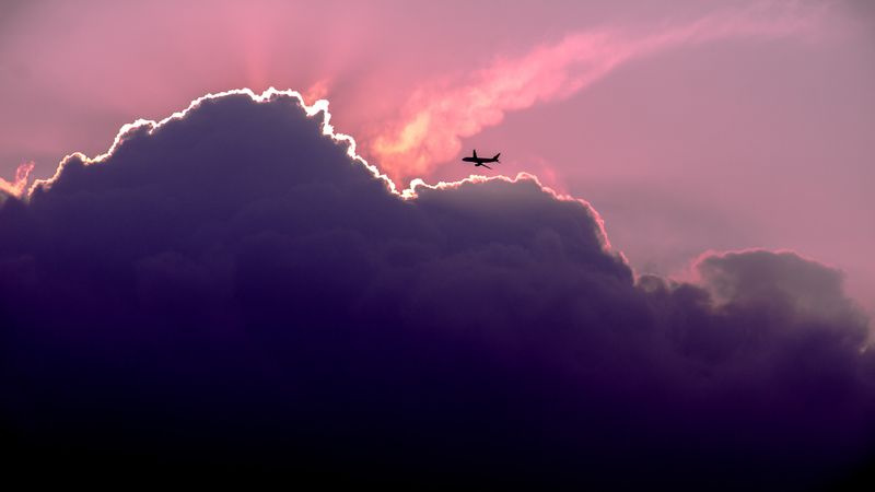 Een vliegtuig vliegt in de buurt van wolken.