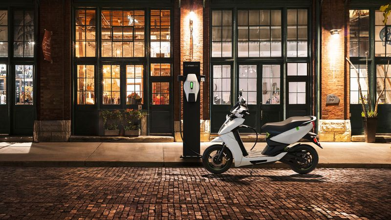 Photo du scooter électrique Ather 4 connecté à une borne de recharge extérieure