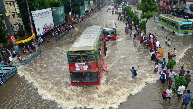 Des véhicules essaient de traverser les rues inondées de Dhaka