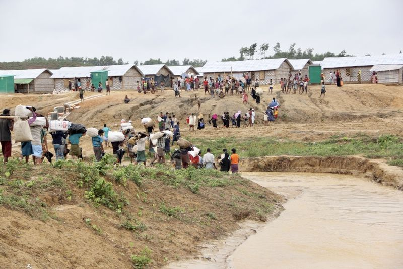 Ein Bild, das eine Gruppe von Rohingya-Flüchtlingen zeigt, die aus Gebieten in der Siedlung Kutupalong, die von Erdrutschen und Überschwemmungen bedroht sind, in sicherere Gebiete umziehen