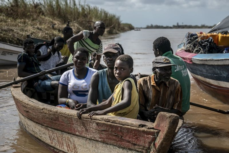 Ein kleines Boot legt mit Bewohnern am Buzi-Dock an. Viele Menschen, die nach dem Zyklon Idai aus Buzi vertrieben wurden, kehren zurück, um den Zustand ihrer Häuser und ihres Eigentums zu überprüfen.