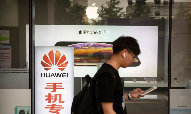 Ein Mann geht an einem Elektronikgeschäft in China vorbei