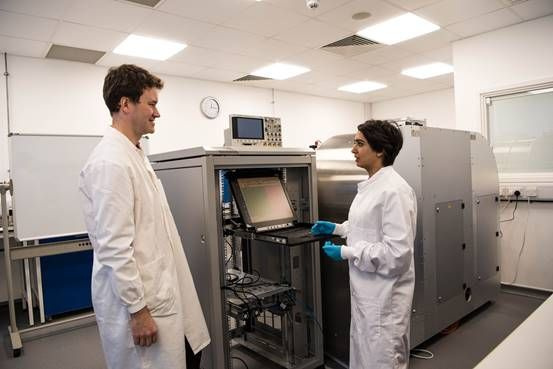 Foto von zwei Forschern, die vor dem Prototyp einer DNA-Datenspeichermaschine stehen