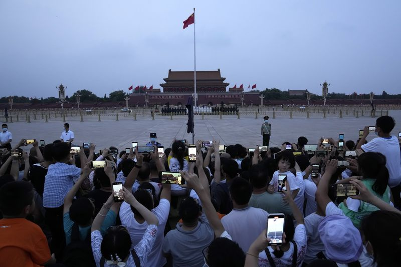 Les résidents se rassemblent pour regarder le drapeau tomber sur la place Tiananmen à Pékin