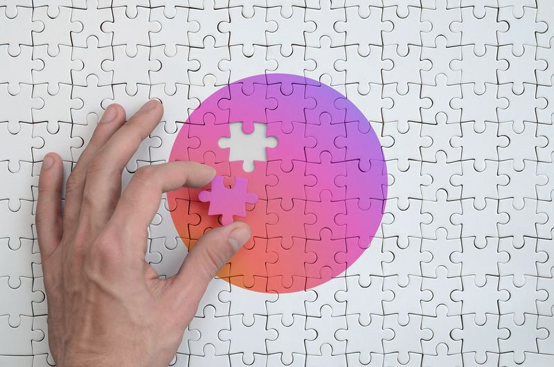 image de la main plaçant une pièce de puzzle dégradée couleurs instagram