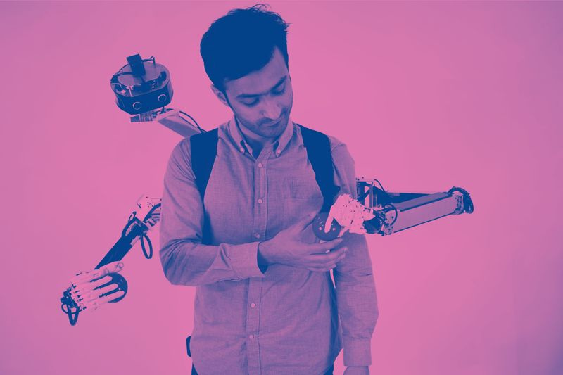 Bild eines Mannes, der einen Ball mit einer Hand des roboterbewaffneten Rucksacks austauscht.