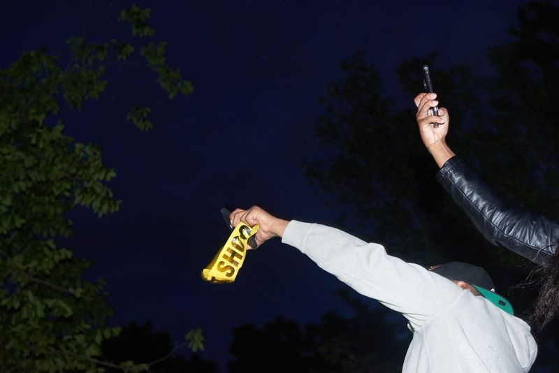 Foto von zwei Demonstranten, die nachts Smartphones hochhalten
