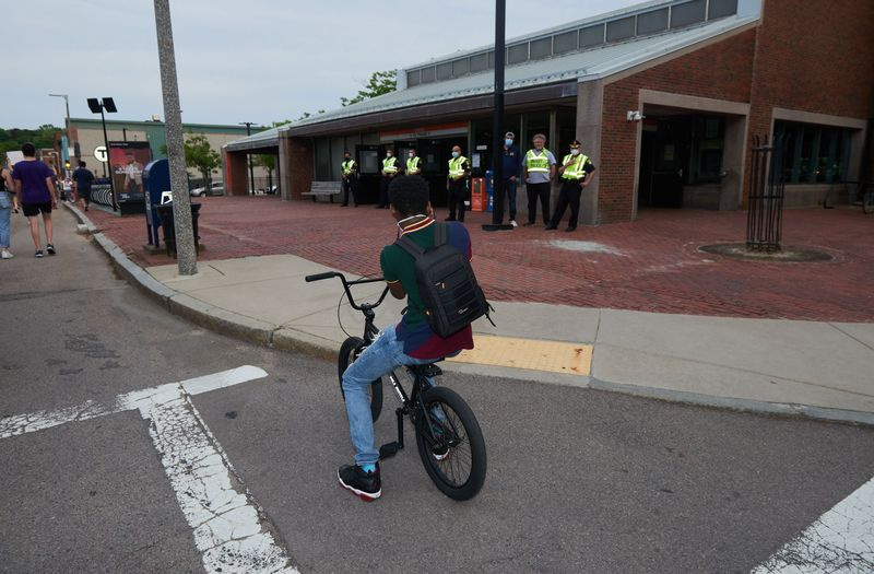 Foto eines kleinen Jungen auf einem BMX-Rad, der die Polizei vor einer MBTA-Station in Boston fotografiert