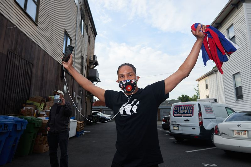 Foto eines Demonstranten in JP, der ein Smartphone hält, während er eine Gesichtsmaske trägt