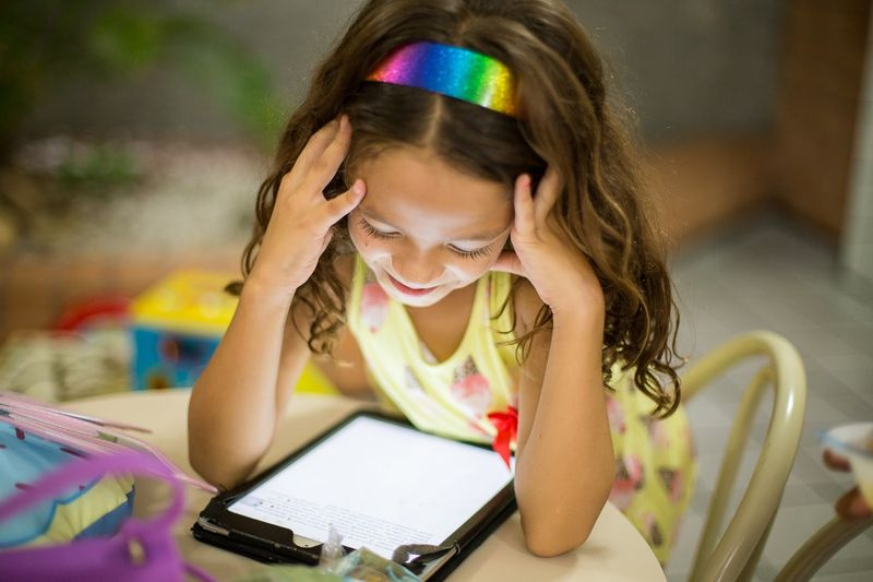 fille avec bandeau arc-en-ciel lecture tablette kindle