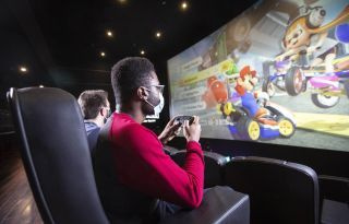 Två spelare tittar upp och spelar på en enorm bioduk