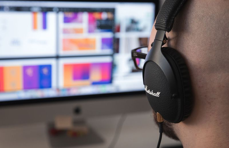 Ein Mann mit Kopfhörern sitzt vor einem Computerbildschirm