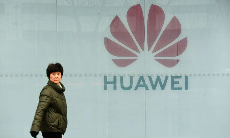 Une femme passe devant le magasin Huawei