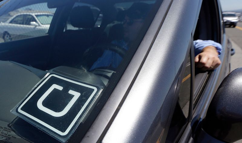 Ein Uber-Fahrer hinter der Windschutzscheibe seines Autos