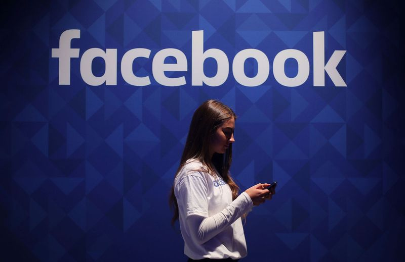 Eine Frau schaut unter Facebook auf ihr Smartphone