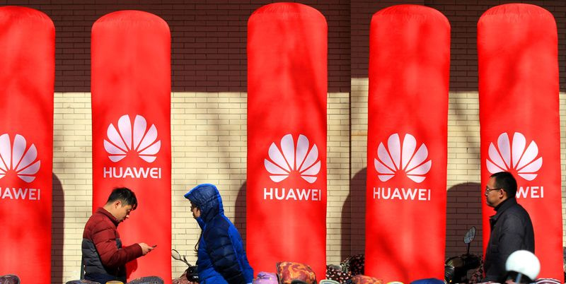 Fußgänger gehen an einer Werbung für Huawei vorbei