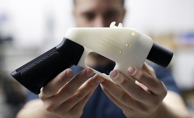 Un homme tenant un pistolet imprimé en 3D