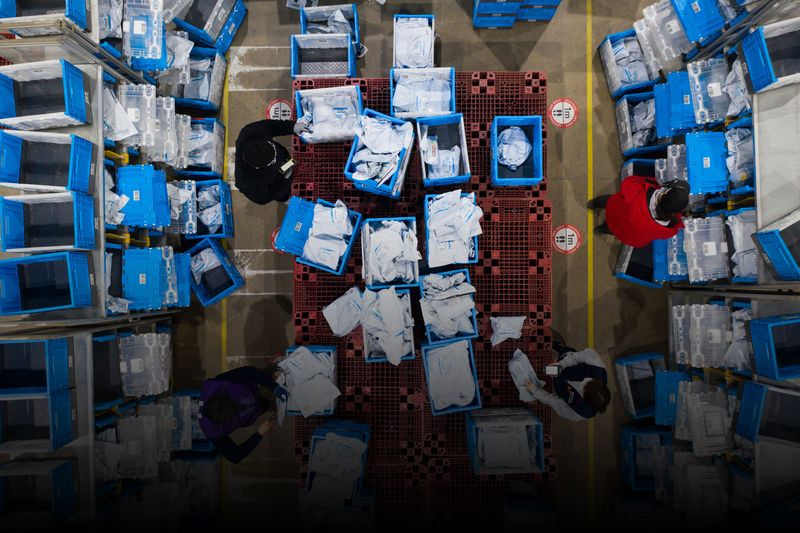 Overhead-Foto zeigt ein Logistikzentrum mit Mitarbeitern, die von Kartons umgeben sind