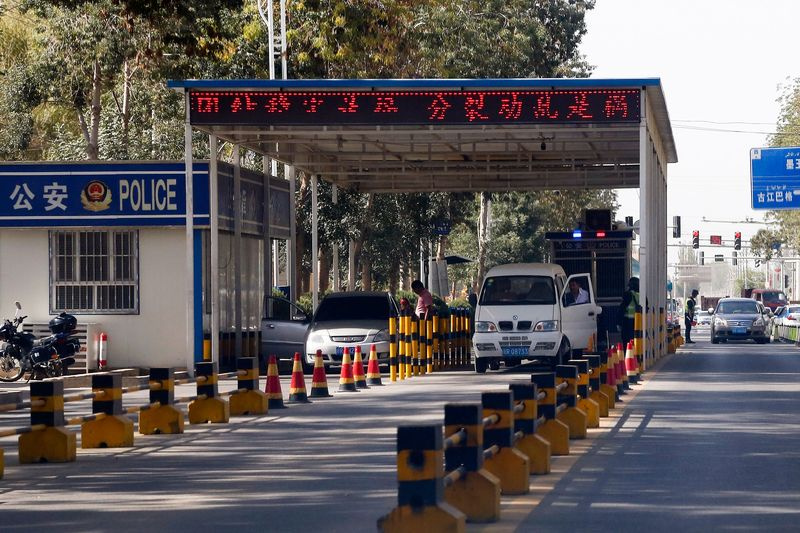 Les conducteurs ouïghours font contrôler leurs véhicules à un poste de contrôle de la police à Hotan
