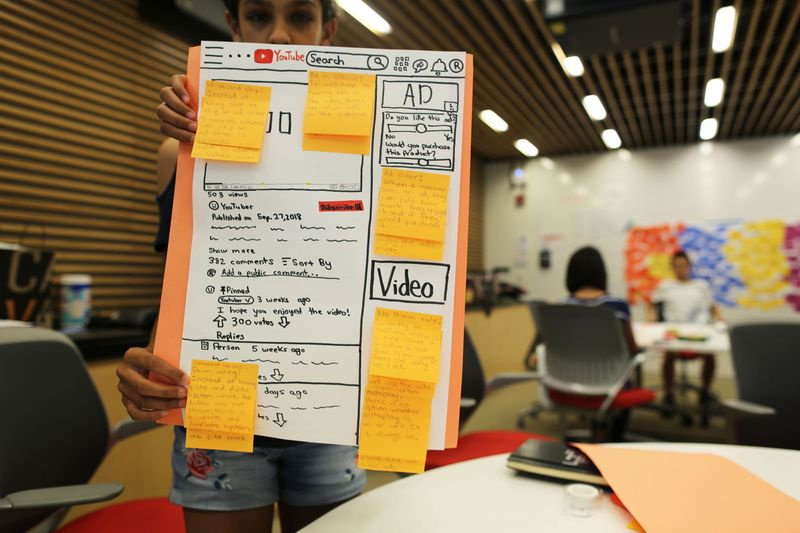 Un étudiant brandit une conception d
