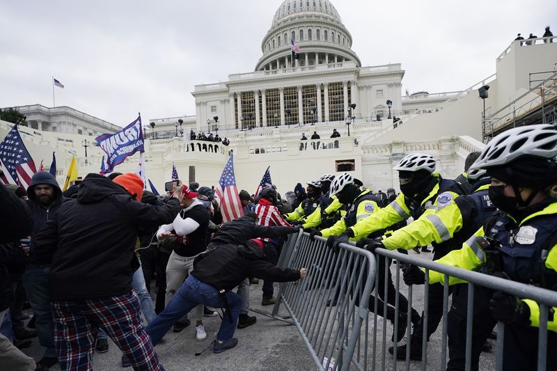 Les partisans de Trump tentent de franchir une barrière policière en route pour occuper le Capitole à Washington.