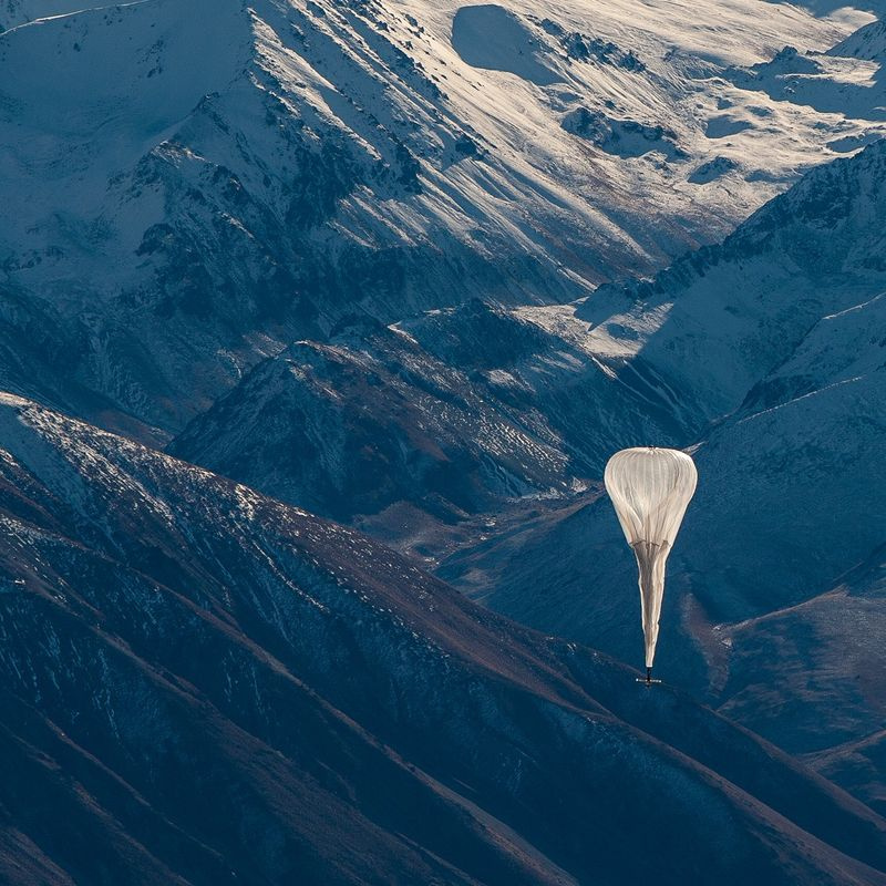 Foto von Loon Ballon, der über Berge fliegt