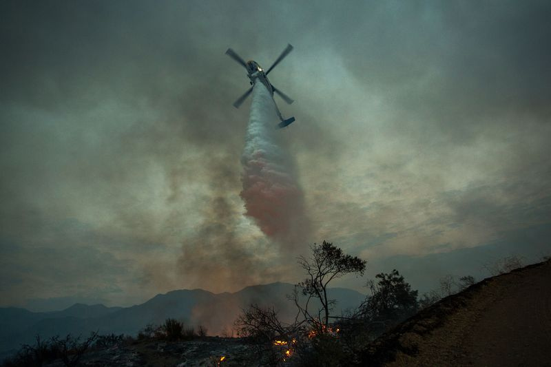 Foto eines Hubschraubers, der einen Waldbrand löscht