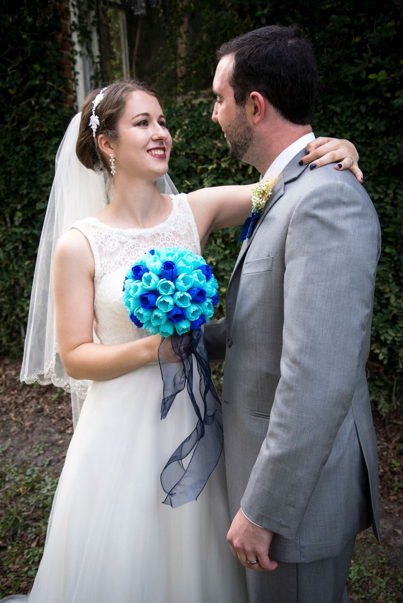 Erin steht mit ihrem Mann und hält ihren Blumenstrauß
