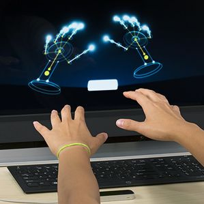 zwei Hände gestikulieren vor dem Monitor
